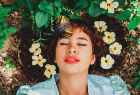 portrait of young Woman with Flowers and Butterfly on hair