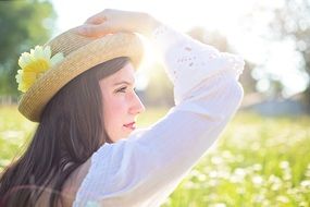 young woman in the bright sun in a summer meadow