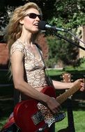 woman with a guitar near the microphone