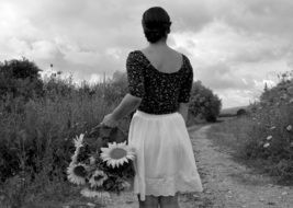 black white photo of a woman with flowers in a basket