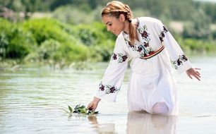 smiling blonde Girl in traditional white dress in water