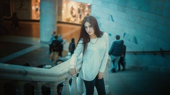 Stylish Beautiful Young girl stands on stairs in shop interior