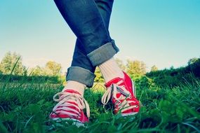 legs in jeans and red sneakers