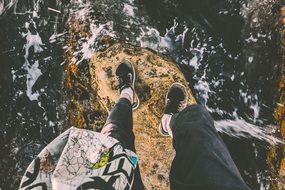 legs hanging from the rock