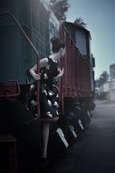 girl in a retro dress on the stairs of the locomotive