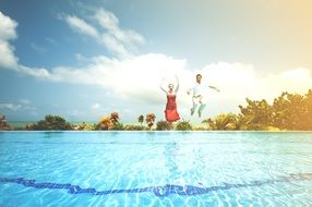 Dressed Woman and Man jumping to swimming pool