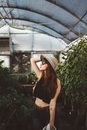 Girl in a greenhouse with green plants