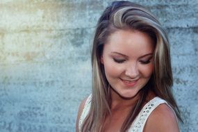 smiling beautiful woman portrait near the wall with light on it