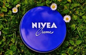 jar of nivea cream on a green meadow with flowers