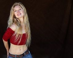 smiling blonde in a burgundy top and jeans