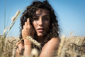 girl with curly hair in a wheat field