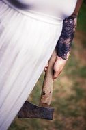 The girl in a white dress with an ax in his hands