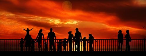 dark silhouettes of a group of people on a background of orange sunset