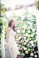 girl in a wedding dress on a background of flowers