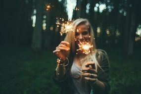 portrait of blonde hair women with fireworks in her hands