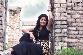 indian girl posing at aged brick wall