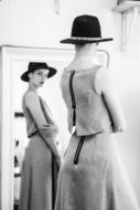 Girl in dress and hat near the mirror