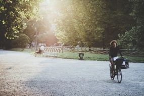 curly woman riding a bike through an empty park