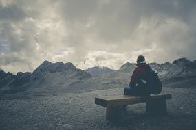 Woman sits on Bench in front of scenic Mountains, germany, bavaria