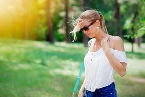girl walks on green grass in the sun