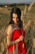 girl in a red dress among the field