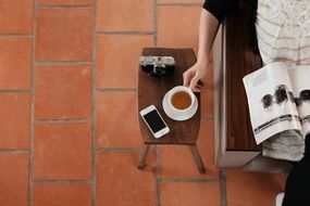 man with a magazine and a cup of coffee