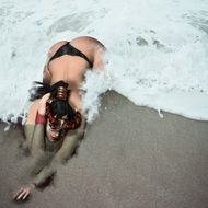 woman on the sand in the waves of the ocean