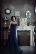 photo portrait of a girl in a dark blue swim by the fireplace