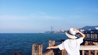 photo of a woman in a white hat in the port city of Xiamen