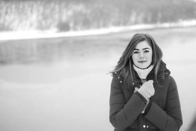 girl in a down jacket at the lake black white portrait