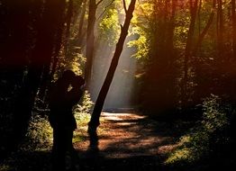 dark silhouette of a couple in love among the forest