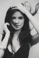 Black and white portrait of a girl with long hair and hands near the face