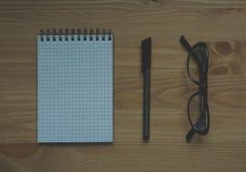 notebook, pen and glasses
