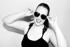 black and white photo of a girl in a black top and sunglasses