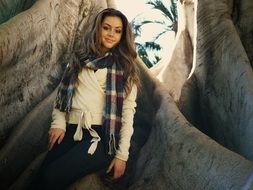 smiling girl on the background of a giant tree trunk