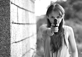 girl aiming a gun black white photo