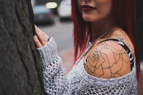 punk-girl with tattoos near a tree