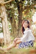 Woman is sitting on the grass outdoors