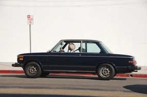 Old Woman driving Vintage Car on road