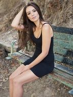 girl in a black tight dress on a bench