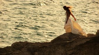 woman in romantic dress on the rock