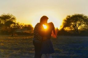 Kissing young Couple at Sunset landscape