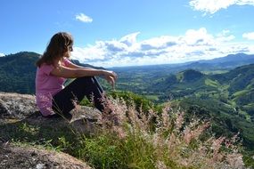 girl in a pink t-shirt on top of a mountain
