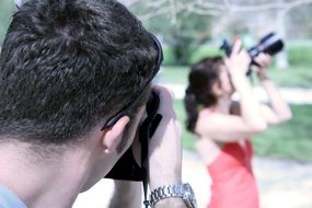 man and woman with cameras