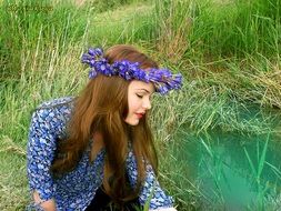 beautiful girl in a blue wreath among nature