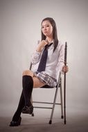 girl posing on a chair near a white wall