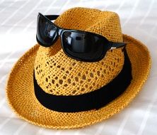 sunglasses on top of a straw hat