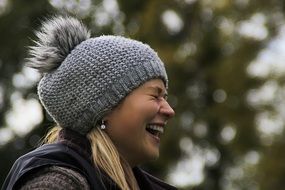 laughing girl in a gray knitted hat