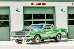 green car at a gas station