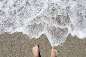 legs of a man on the beach near the water